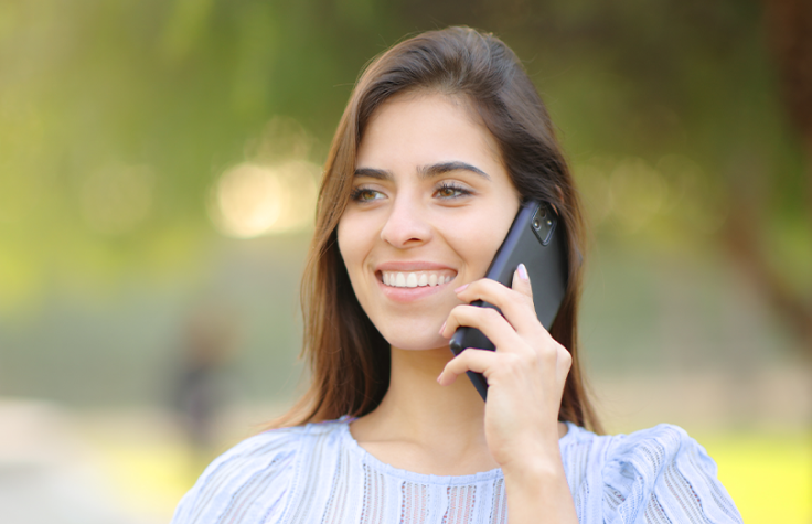 Uśmiechnięta kobieta rozmawia przez telefon