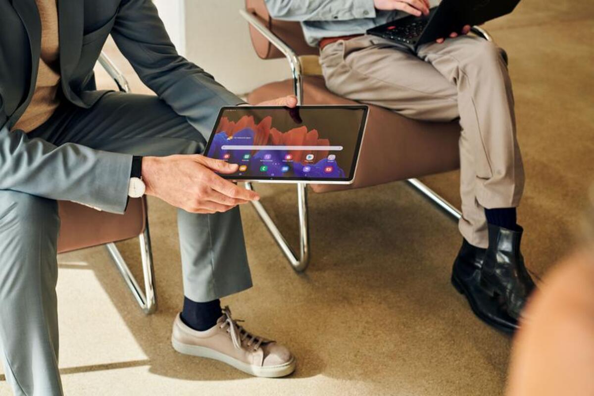 Mężczyzna trzyma w ręku tablet podczas spotkania biznesowego