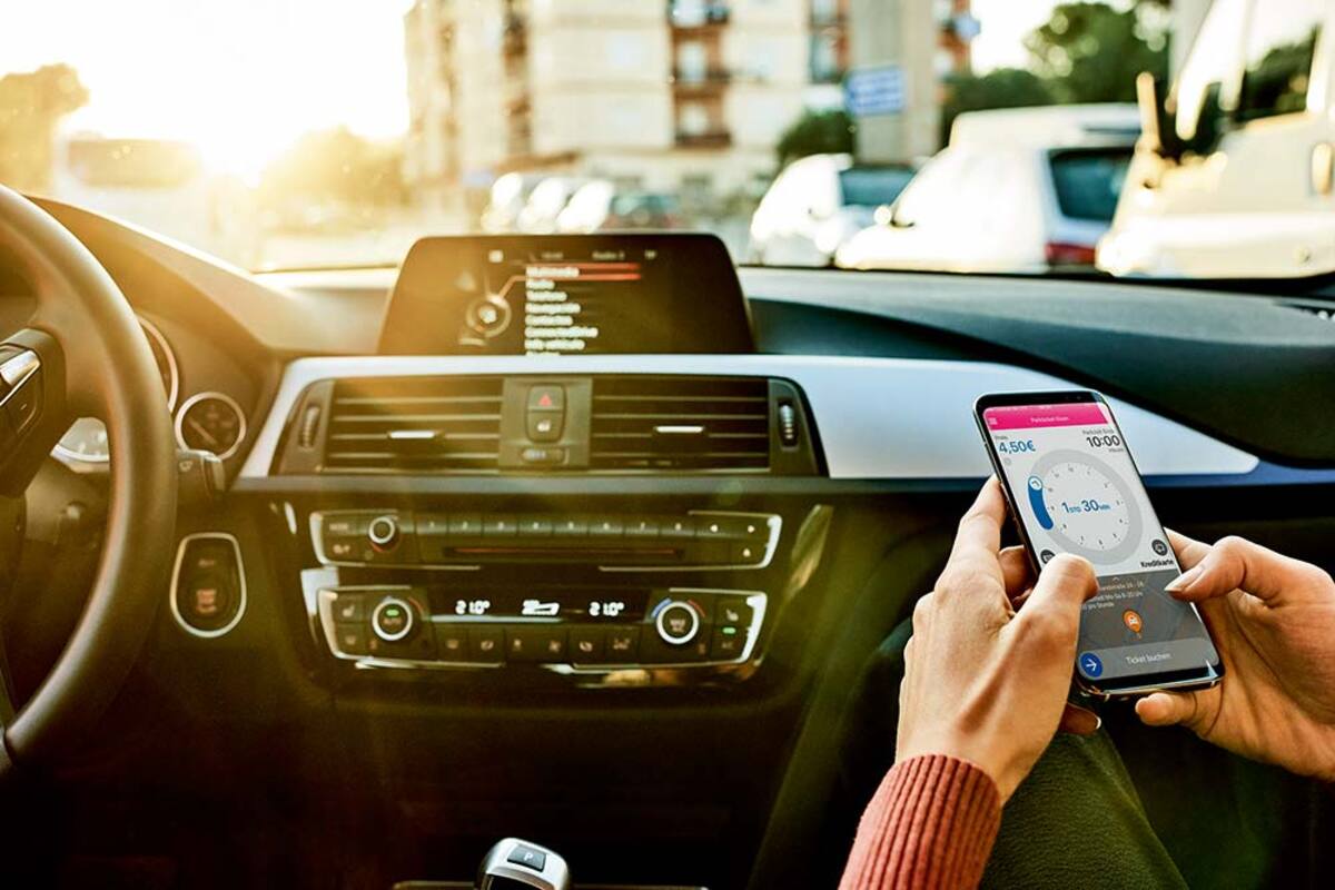 Pasażer w samochodzie korzysta z aplikacji w smartfonie.